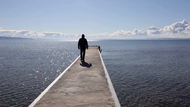 スウェーデンのヴィシンソ晴れた日に男がヴァターン湖のドックに出て行く — ストック動画