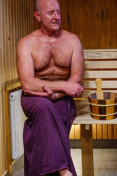 A man sweats in a sauna.
