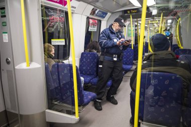 Stockholm, İsveç. Bir bilet kontrolörü, bir yolcunun metro ya da tüneldeki biletini kontrol eder..