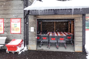 Riksgransen, İsveç Alışveriş arabaları bir ICA süpermarketinin önünde kar fırtınasında.