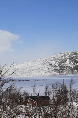Tornestrask, İsveç İlkbaharda Tornetrask Gölü üzerinde karlı ve kutup manzarası ve küçük bir kulübe.