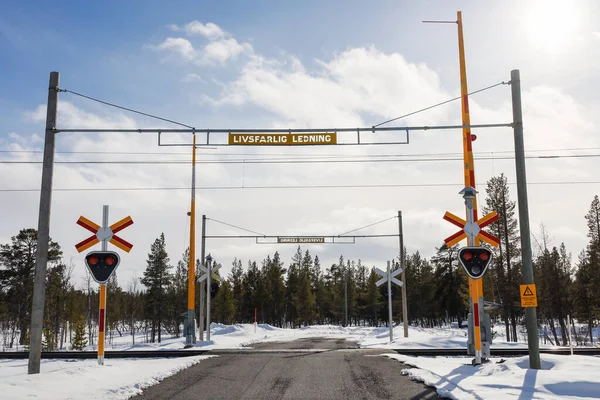 Kiruna, Sweden A train crossing on a road, sign says in Swedish: dangerous crossing.