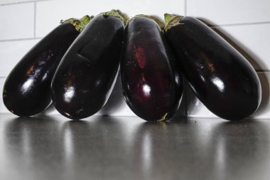 Mutfak tezgahına yaslanmış dört patlıcan..