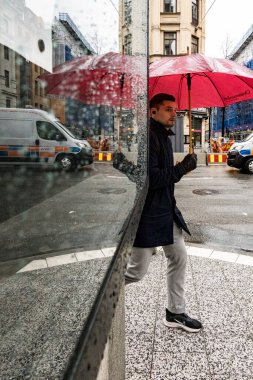 Stockholm, İsveç Vasagatan 'ın köşesinde pencereye yansıyan bir adam yürüyor..