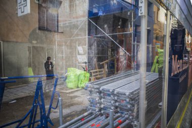 Stockholm, İsveç 'te telefondaki bir kadın bir inşaat sahasının plastc kapağına yansıyor..
