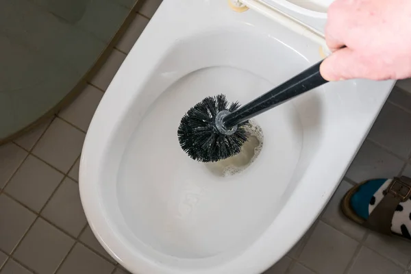 Een Man Reinigt Een Toiletpot Met Een Borstel — Stockfoto