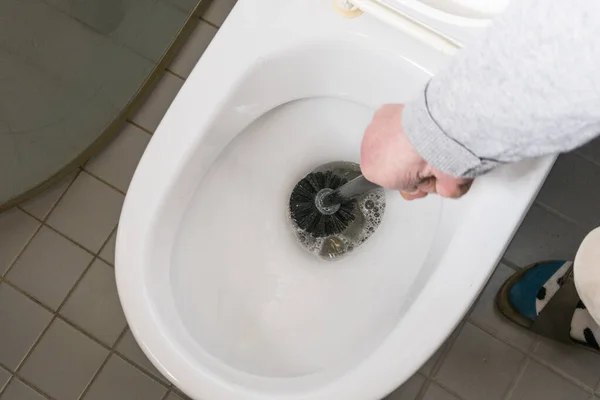 Een Man Reinigt Een Toiletpot Met Een Borstel — Stockfoto