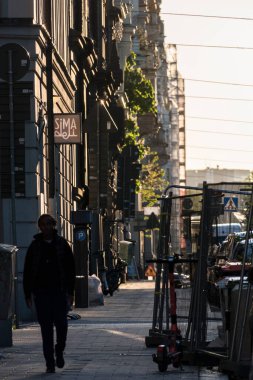Stockholm, İsveç 'te güneş batarken Valahallavagen' da bir adam siluet içinde yürüyor..