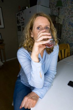 Mutfak masasında çay içen bir kadın..