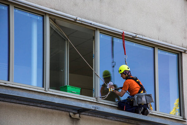 Stockholm, Sweden  A window washer attached to a harness.