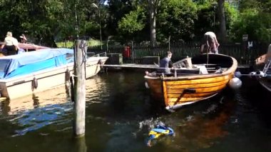 Stockholm, İsveç 6 Mayıs 2021 Palsundet Kanalı 'ndaki klasik ahşap bir tekneden İsveç bayrağı suya düştü..  