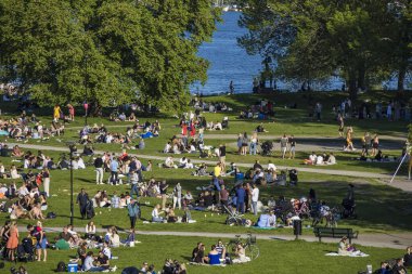 Stockholm, İsveç 'te güneşli bir günde Ralambshovs parkında toplanan insanlar kısıtlamalar kaldırıldıktan sonra.