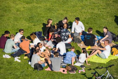 Stockholm, İsveç 'te güneşli bir günde Ralambshovs parkında toplanan insanlar kısıtlamalar kaldırıldıktan sonra.