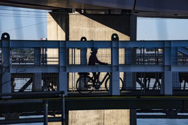 Stockholm, İsveç Lidingo köprüsünde bisiklet yolunda bir bisikletçi