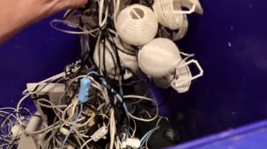 Bir adam geri dönüşüm için çöp kutusuna elektrik atığı atıyor.