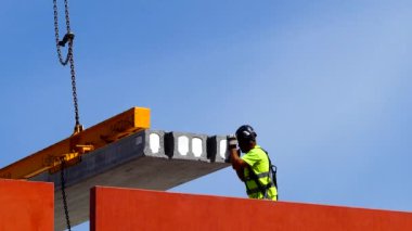 Malmö, İsveç şehir merkezindeki bir inşaat işçisi vinçteki beton levhayla ilgileniyor.. 