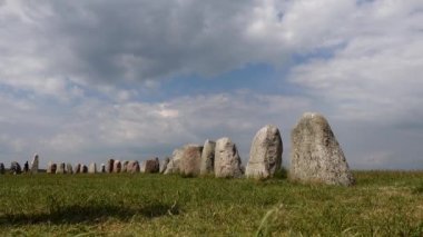 İsveç, Ales Stenar Güney İsveç 'te gemi şeklinde 1000 yıllık kaya oluşumunun ortasında yürüyen bir turist..