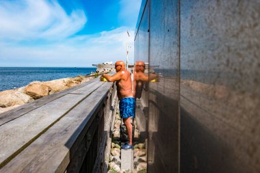 Malmö, İsveç. Kıdemli bir adam şehrin Vastra Hamnen bölgesindeki ScaniaParken 'de güneşleniyor..