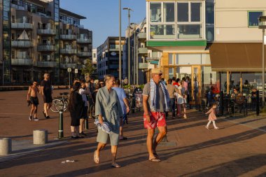 Malmö, İsveç insanlar şehrin Vastra Hamnen bölümünde günbatımının tadını çıkarıyorlar, ve bir çift banyo yapmaya hazır..