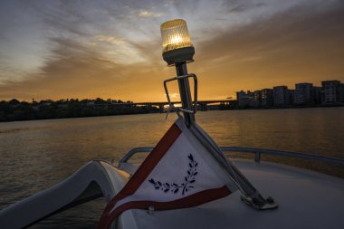 Stockholm, İsveç Stockholm 'de gün batımında küçük bir teknede seyir ışığı ve tekne kulübünü temsil eden bayrak..