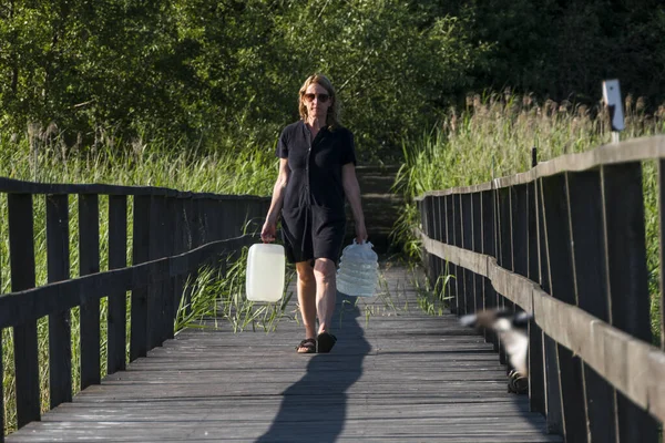 スウェーデンのエケロ女性はドックに飲料水のジャグを持っています — ストック写真