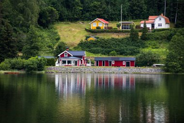 İsveç 'in batısındaki Dalsland Kanalı boyunca bir köprü üzerindeki suya bir ev yansıtılır..