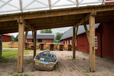 Hofsnas, İsveç Büyük bir ahırın bahçesine küçük bir kayık park edilmiş.