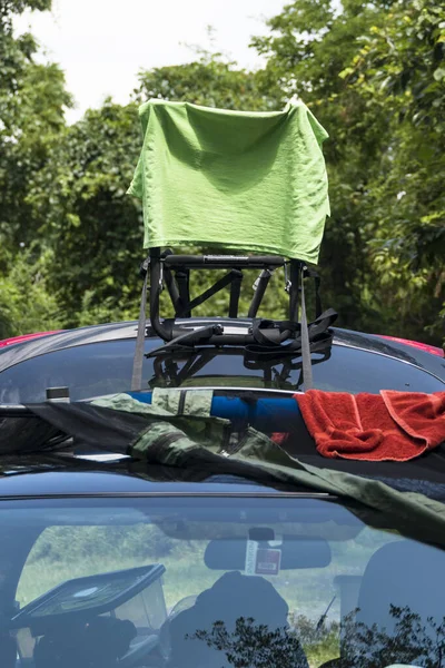 A T-shirt hangs to dry on a bike rack on a car.