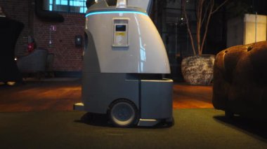 Bir robot elektrikli süpürge yerde yuvarlanıyor..