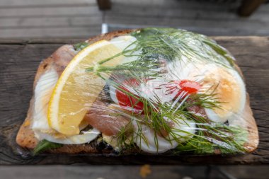Stockholm, Sweden A classic egg and anchovy open sandwich with dill wrqpped in plastic.