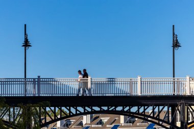 Chesapeake Sahili, Maryland ABD 16 Mart 2025 Tarihi şehir merkezinde yaya köprüsünde yürüyen insanlar.