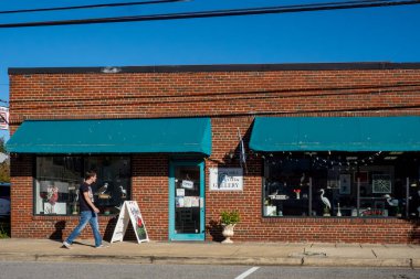 Kuzey Sahili, Maryland ABD 16 Ekim 2025 Bir genç adam kırmızı tuğladan bir binadaki sanat galerisinin önünden geçiyor.