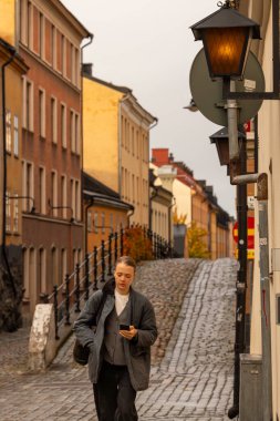 Stockholm, İsveç 28 Ekim 2025 Sodermalm bölgesindeki tarihi Brannkyrkagatan caddesinde bir yaya yürüyor..