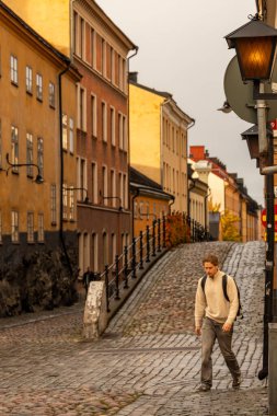 Stockholm, İsveç 28 Ekim 2025 Sodermalm bölgesindeki tarihi Brannkyrkagatan caddesinde bir yaya yürüyor..