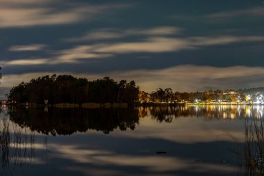 Stockholm, İsveç Solna ve Danderyd banliyöleri arasında küçük bir koy olan Edsviken 'in suları üzerinde bir gece manzarası ve bulutlu bir yer..