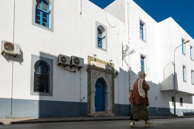 Susa, Tunus 3 Kasım 2025 Bir kadın şehir merkezinde beyaz yıkamalı bir ampulle yürüyor.. 