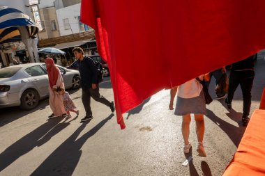 Manastır, Tunus 5 Kasım 2025 Medine 'de kırmızı bir tentenin altında yürüyen yayalar.