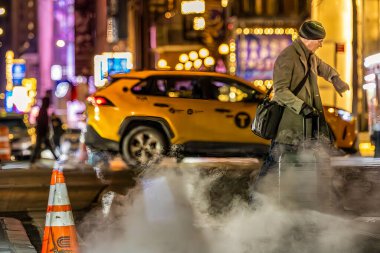 New York, New York, ABD 9 Aralık 2025 gece şehir merkezindeki 6. Cadde 'de buharlı ve farlı yayalar..