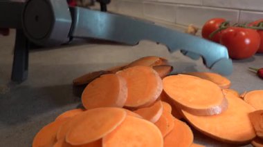 Stockholm, İsveç 'te bir aşçı bir ev mutfağında tatlı patatesleri dilimliyor.. 