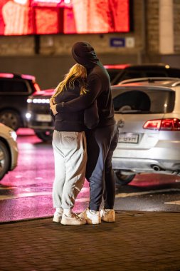 Tallinn, Estonya 15 Aralık 2025 Bir yaya çifti gece bir kavşakta kucaklaşıyor