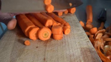 Stockholm, İsveç. Ahşap bir tahtanın üzerinde, mutfakta havuç doğrayıp doğrayan bir aşçı..