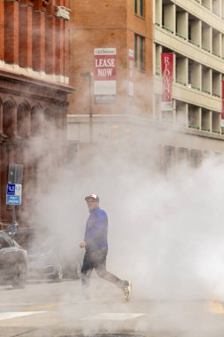 Baltimore, Maryland ABD 6 Ocak 2026 Buhar bulutları arasında yürüyen yayalar Batı Redwood Caddesi ve S Eutaw Caddesi şehir merkezinde.