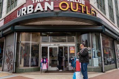 Baltimore, Maryland 6 Ocak 2026 Lexington ve Park Bulvarları 'ndaki Urban Outlet mağazasından bir erkek yaya geçiyor.
