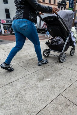 Baltimore, Maryland ABD 6 Ocak 2026 Sigara içen bir kadın şehir merkezinde bebek arabası itiyor.