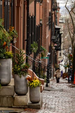 Boston, Mass, ABD 9 Ocak 2026 Beacon Hill tarihi bölgesinde kırmızı tuğlalı evler ve bir yaya..