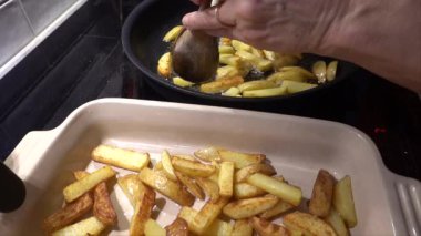 Stockholm, İsveç. Mutfak mutfağında aşçı. Bir tencere yağda patates kızartması..