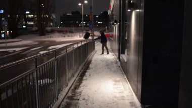 Stockholm, İsveç 'te bir apartman dairesinde bir adam kışın erken saatlerinde halka açık yollarda kar sürer..