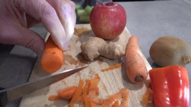 Stockholm, İsveç Smoothie yapmak için havuç doğrayan bir adam.