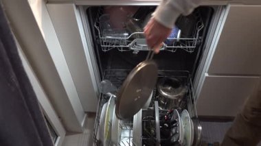 Stockholm, İsveç Bir adam bulaşık makinesini dolduruyor.