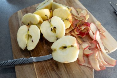 Stockholm, İsveç Soyulmuş kırmızı elmalar kabuklu kesme tahtasında.